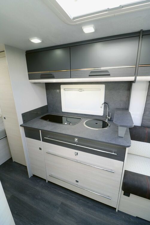 Élégante, la cuisine avec support rehaussé brille par son équipement complet, ses fermetures sécurisées et ses espaces de rangement suffisants.