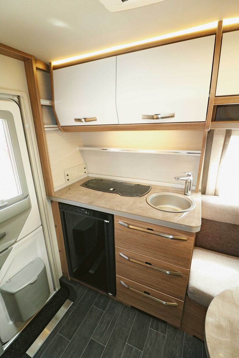 La cuisine compacte à l’arrière est esthétique, fonctionnelle et pourvue de tout l’équipement essentiel.