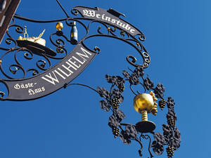 Enseigne en fer forgé d’un restaurant, où les couverts sont déjà plantés dans le rôti de quoi préparer au mieux ses papilles pour les délicieuses spécialités de la région.