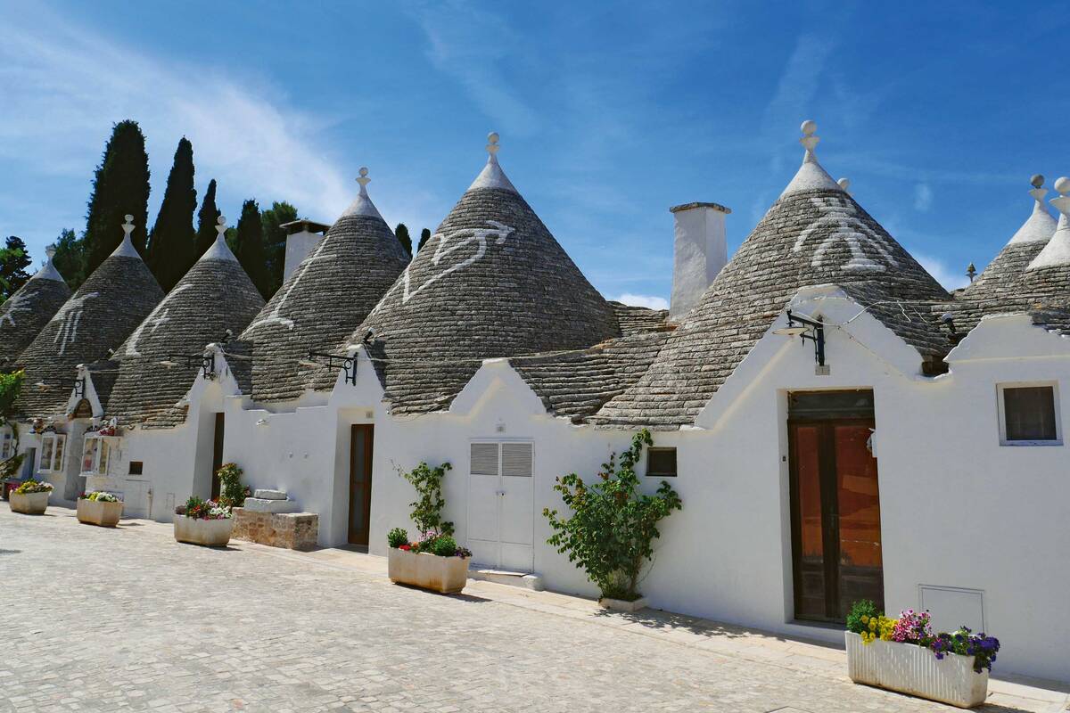 Des symboles de protection sur les toits en forme de cône couleur pierre naturelle des trulli d’Alberobello.