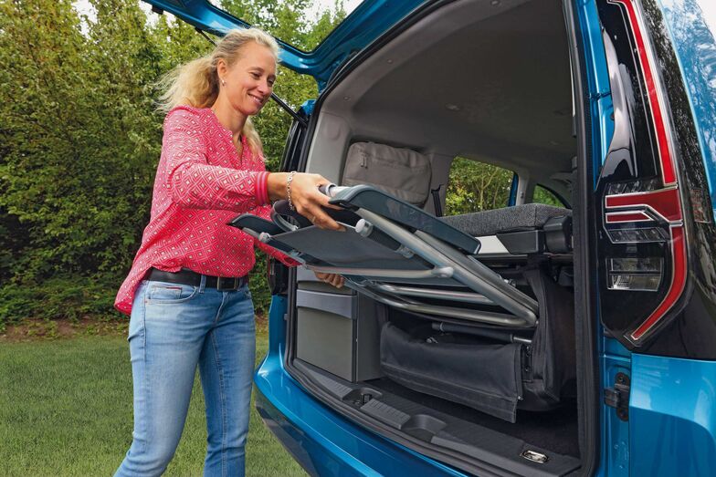 Zwei Campingstühle und ein Campingtisch können in einer Tasche unter dem Bett verstaut werden.