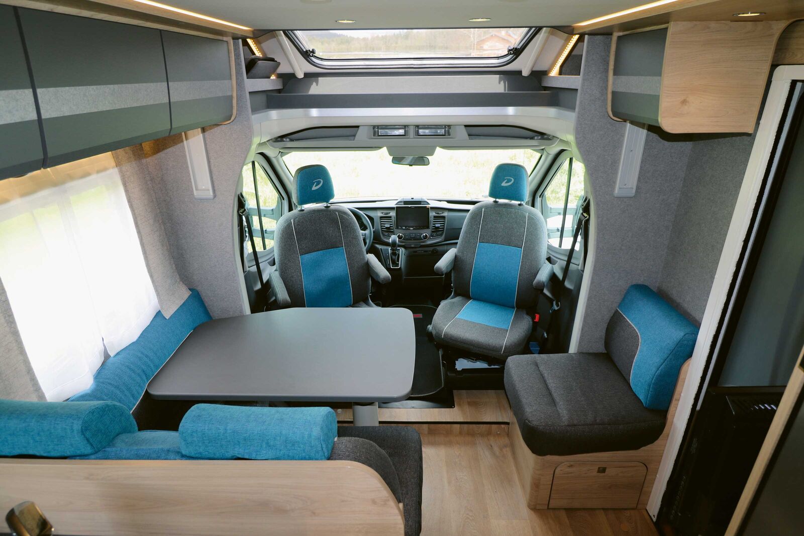 Die bequeme Sitzlandschaft um den freistehenden Tisch sorgt zusammen mit den harmonisch abgestimmten Dekor-Farben für eine angenehme Wohnatmosphäre.