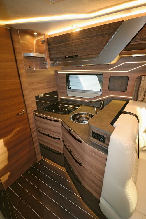 Élégante, la cuisine brille également par son espace de rangement, sa plaque de cuisson trois feux avec allumage électrique et couvercle en verre, et son évier rond en inox avec mitigeur de style domestique.