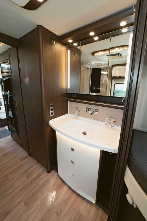 Im wagenbreiten Sanitärbereich sind rechts Waschtisch und Kleiderschrank eingebaut.