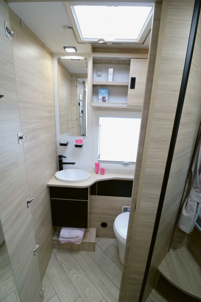 La fenêtre dépolie, la lucarne et le mobilier clair font paraître la pièce plus grande.