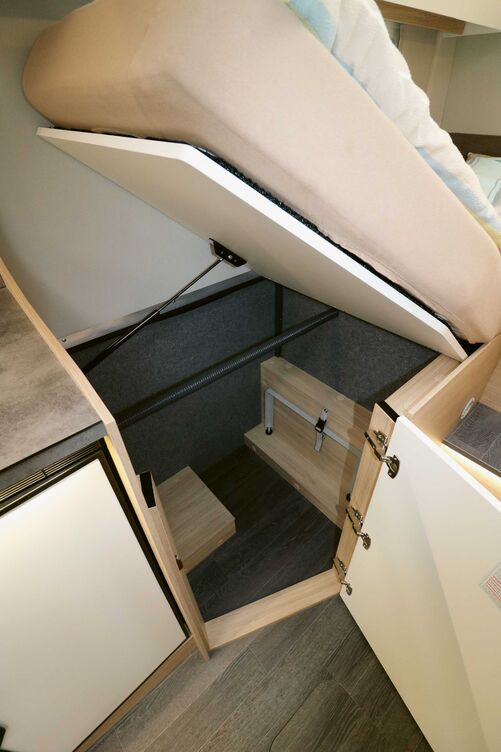 Sous le lit droit, la penderie est également accessible par le haut.