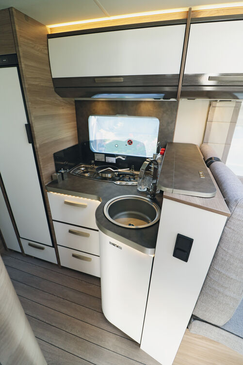 Élégante, la cuisine brille également par son espace de rangement, sa plaque de cuisson trois feux avec allumage électrique, grille en font et couvercle en verre, et son évier rond en inox avec mitigeur de style domestique.