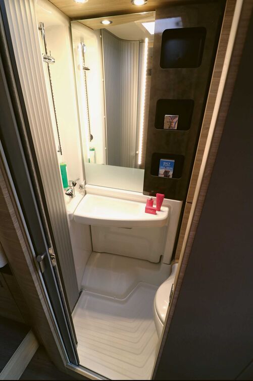 Dans l’espace sanitaires fonctionnel avec porte coulissante, la paroi du lavabo pivote facilement sur le côté afin de créer un espace douche isolé.