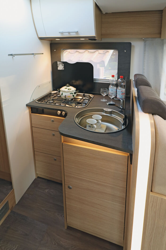 Bloc cuisine élégant avec placard bas en angle et nombreux éclairages.