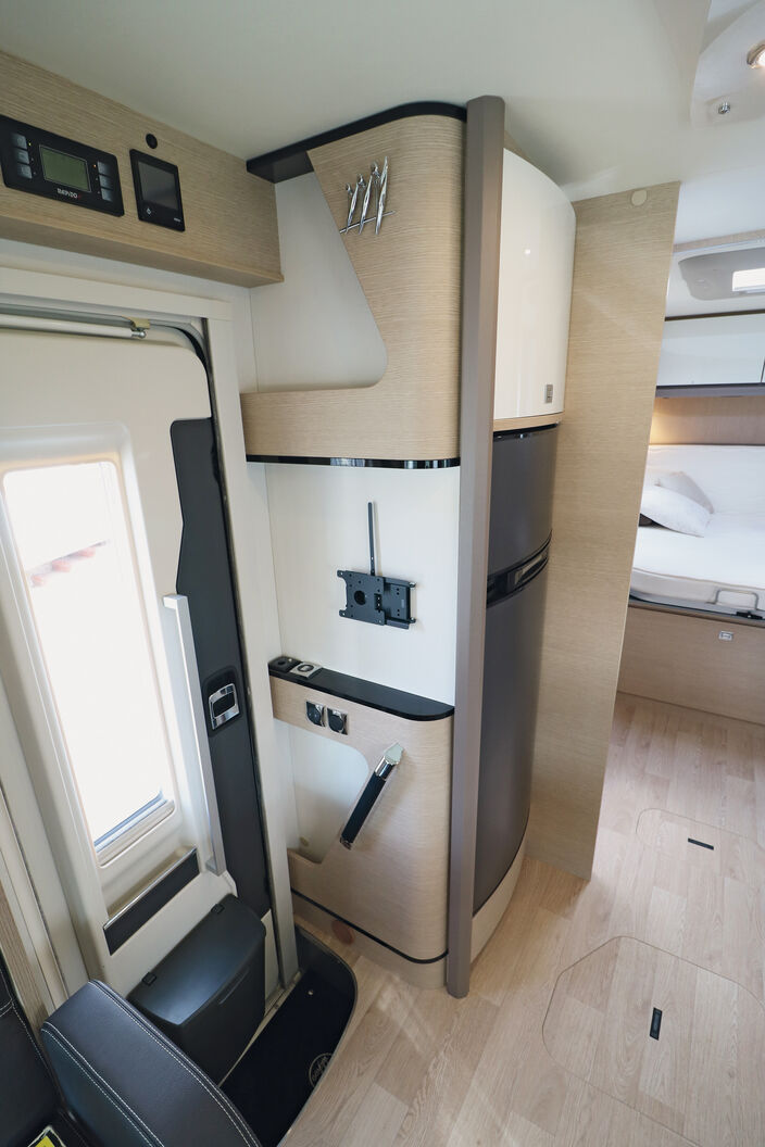 Entrée bien réalisée avec crochets, étagères et support TV pratiques.