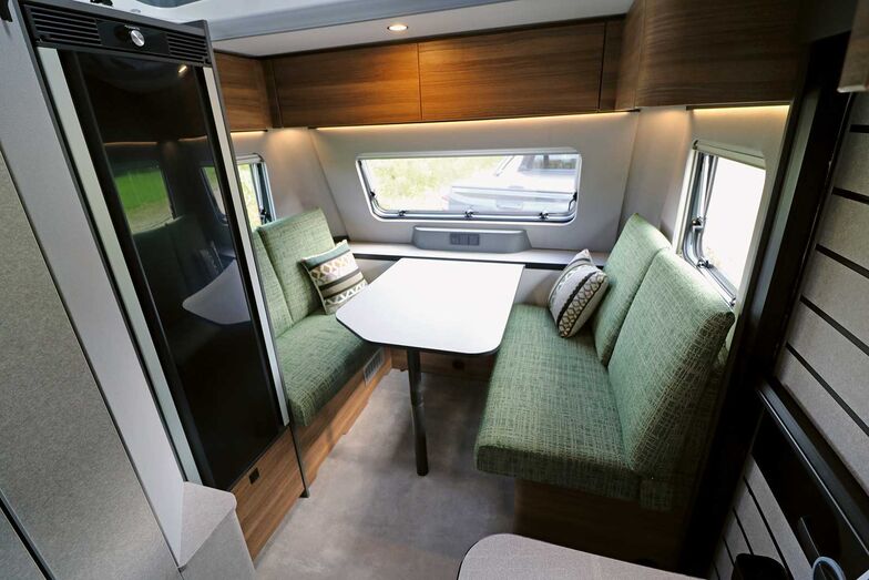 Das Interieur mit der Kombination aus Grautönen sowie wohnlichen Stoff- und Holzoberflächen schafft zusammen mit den zahlreichen Lichtquellen für eine behag­liche Wohnatmosphäre.