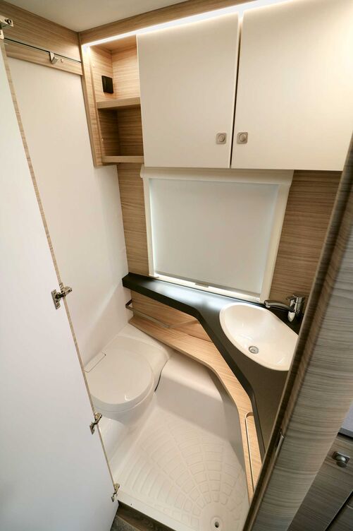 Der helle Waschraum mit der formschönen WC-Bank und dem über Eck platzierten Waschbecken lässt trotz kompakter Grundfläche nichts vermissen.