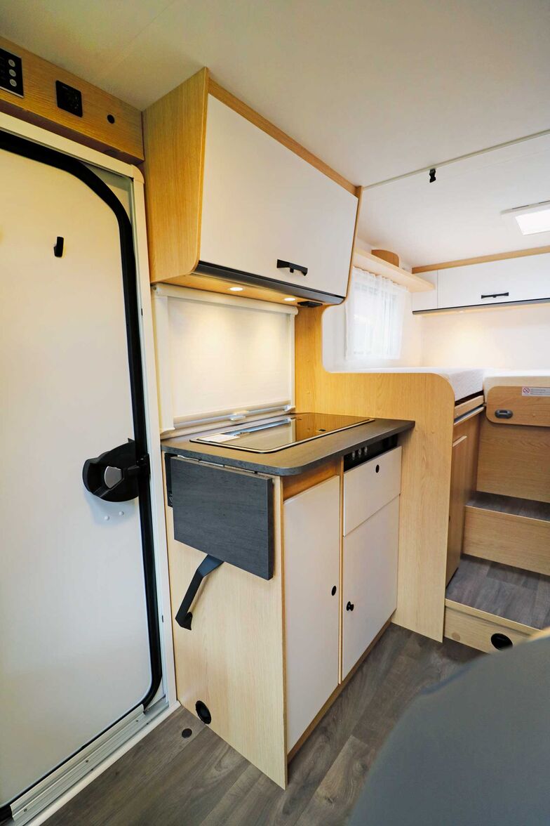 Die kompakte Küche neben der Eingangstür enthält alles Wesentliche und kann mit den hellen Fronten auch optisch gefallen.