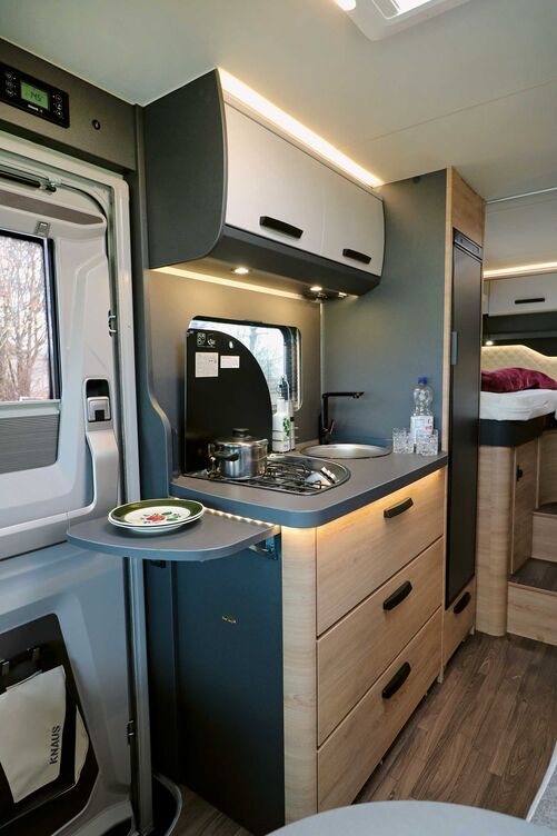 Die auch optisch ansprechende Küche im Kompaktformat bietet ausreichend Stauraum im Ober- und Unterschrank sowie einen funktionalen Dreiflammherd mit elektrischer Zündung, Gussrost und Glasabdeckung.